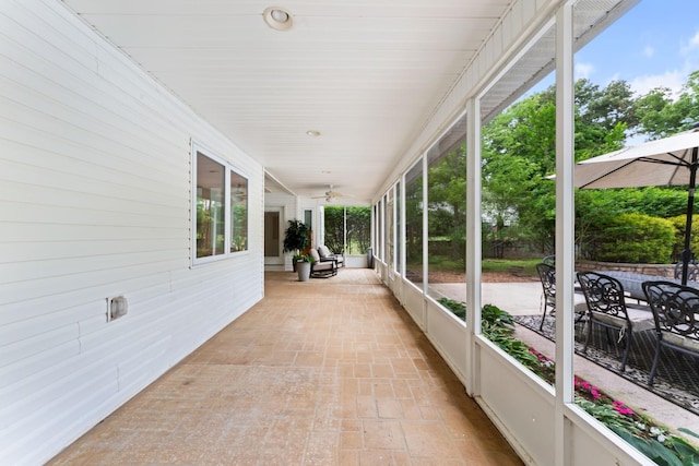 sunroom / solarium featuring a ceiling fan