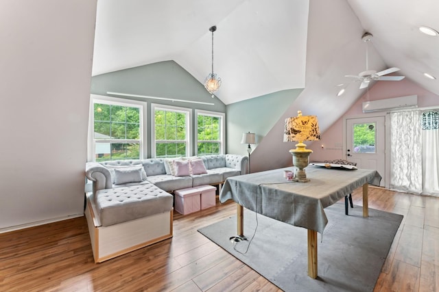recreation room featuring vaulted ceiling, a wall unit AC, ceiling fan, and hardwood / wood-style flooring