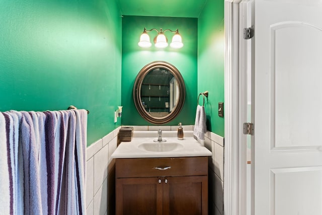 bathroom featuring tile walls, wainscoting, and vanity