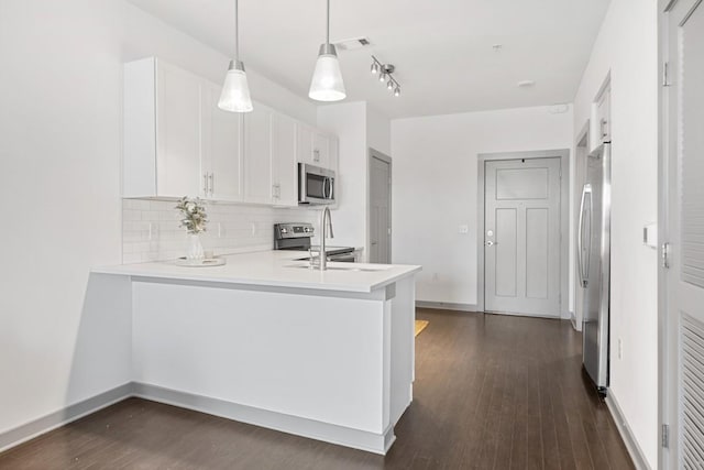 1638 54th Ave N Unit 313, Nashville, TN 37209 - kitchen featuring decorative backsplash, dark wood-type flooring, a peninsula, and appliances with stainless steel finishes