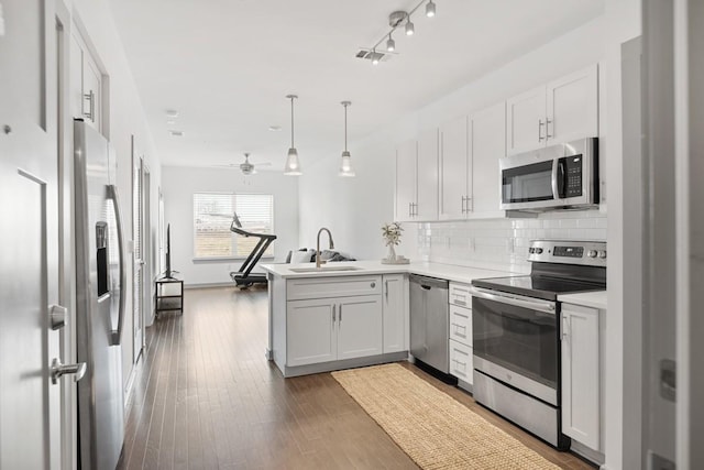 1638 54th Ave N Unit 313, Nashville, TN 37209 - kitchen featuring decorative backsplash, a sink, hardwood / wood-style flooring, a peninsula, and appliances with stainless steel finishes