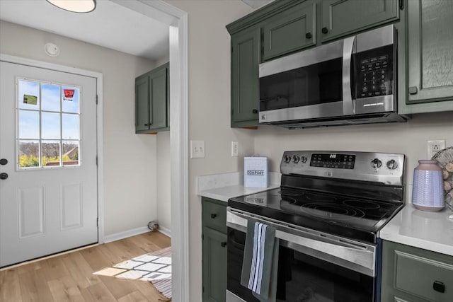 650 Wall Rd, Cunningham, TN 37052 - kitchen with light countertops, baseboards, light wood finished floors, green cabinetry, and appliances with stainless steel finishes