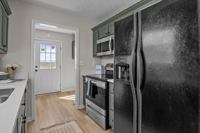 650 Wall Rd, Cunningham, TN 37052 - kitchen with baseboards, light countertops, stainless steel appliances, and light wood finished floors