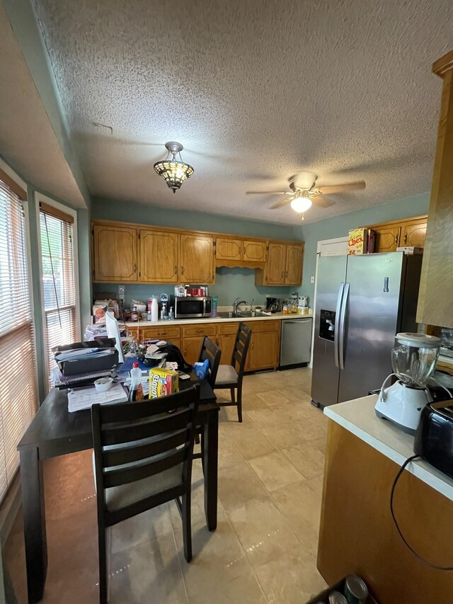 1222 Marla Dr, Clarksville, TN 37042 - kitchen featuring stainless steel appliances, a sink, brown cabinetry, a textured ceiling, and light countertops