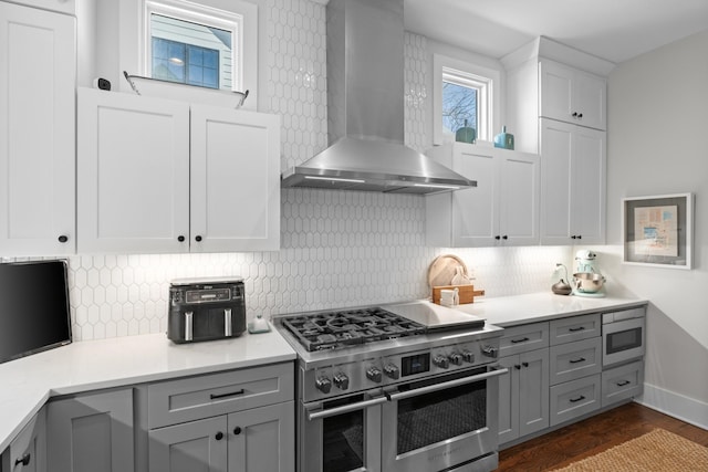 128 37th Ave N, Nashville, TN 37209 - kitchen with decorative backsplash, gray cabinets, appliances with stainless steel finishes, and wall chimney range hood