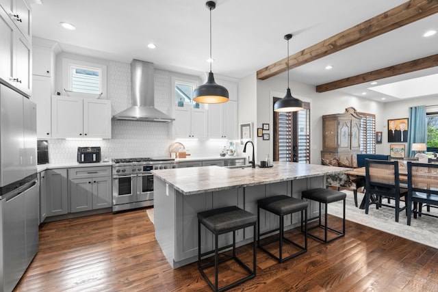 128 37th Ave N, Nashville, TN 37209 - kitchen featuring decorative backsplash, dark wood-style flooring, a sink, stainless steel appliances, and wall chimney exhaust hood