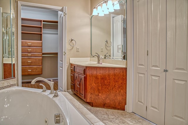 bathroom featuring vanity, a jetted tub, and a closet
