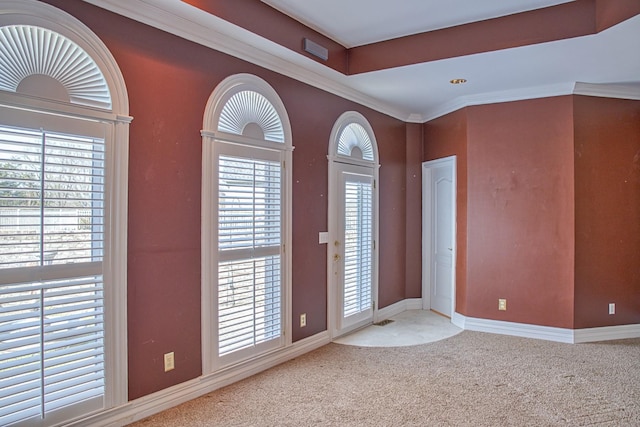 carpeted foyer entrance featuring baseboards and ornamental molding
