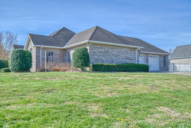 single story home featuring aphalt driveway, a garage, brick siding, a front lawn, and a shingled roof