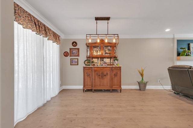 dining room with baseboards, light wood-type flooring, crown molding, and recessed lighting