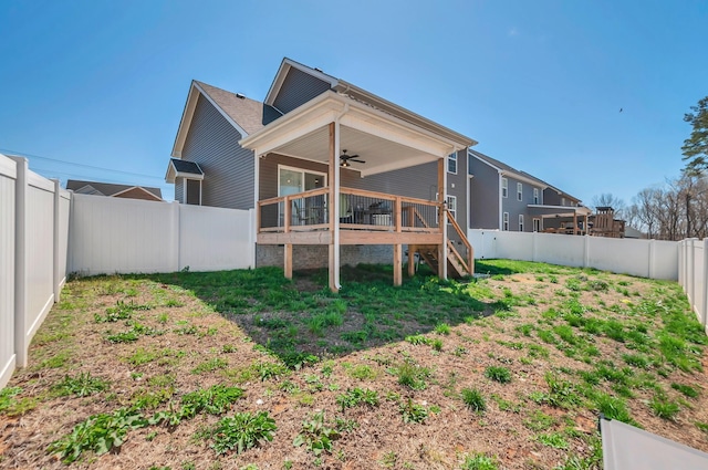 rear view of house featuring a fenced backyard, a ceiling fan, a yard, and a wooden deck
