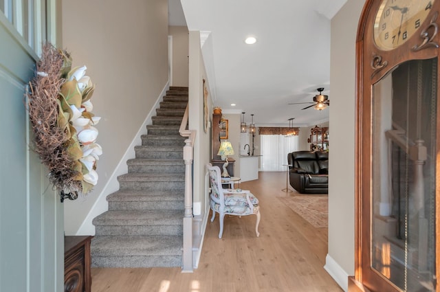 foyer entrance with stairs, light wood finished floors, baseboards, ceiling fan, and recessed lighting