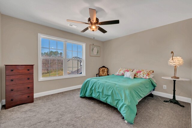 carpeted bedroom featuring baseboards, ceiling fan, and visible vents