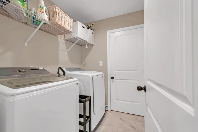 washroom with marble finish floor, washing machine and clothes dryer, and laundry area