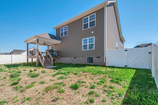 back of house with stairs, a wooden deck, a fenced backyard, a gate, and a yard