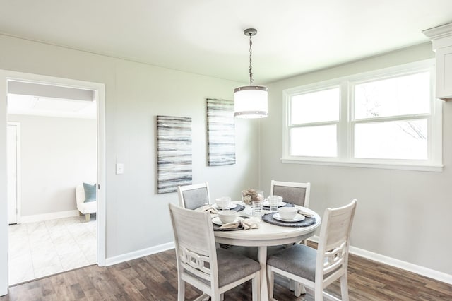 dining room featuring dark wood finished floors and baseboards