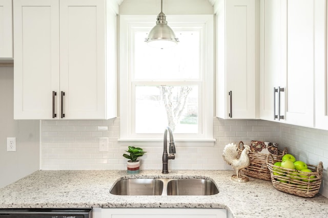 kitchen with dishwasher, tasteful backsplash, white cabinetry, a sink, and hanging light fixtures