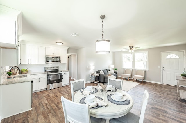 dining room with a ceiling fan, dark wood-type flooring, baseboards, and visible vents