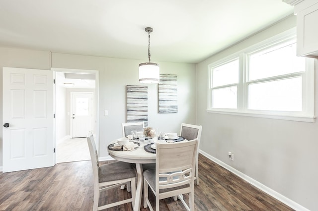 dining space with dark wood-type flooring and baseboards