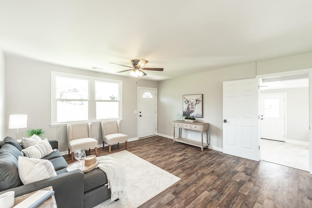 living room with wood finished floors, visible vents, baseboards, and ceiling fan