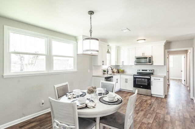 dining space with dark wood-style flooring, baseboards, and visible vents