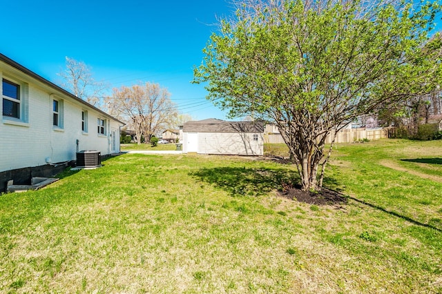 view of yard featuring fence and central AC