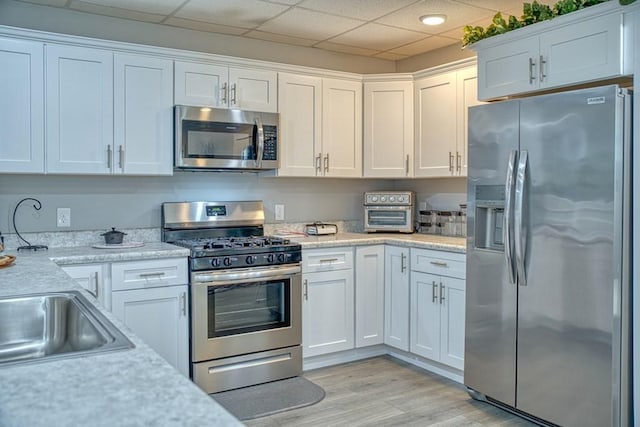 kitchen featuring white cabinets, light countertops, and stainless steel appliances