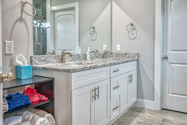 bathroom with a sink, baseboards, and double vanity