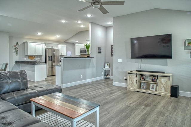 living room with light wood-style flooring, baseboards, ceiling fan, recessed lighting, and lofted ceiling