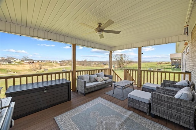 wooden terrace with an outdoor living space and ceiling fan