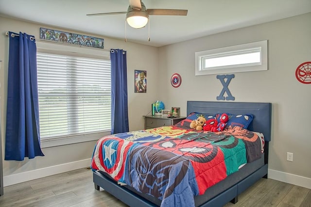 bedroom with baseboards, wood finished floors, and a ceiling fan