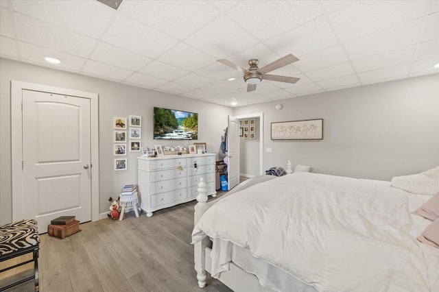 bedroom with a paneled ceiling, recessed lighting, ceiling fan, and wood finished floors