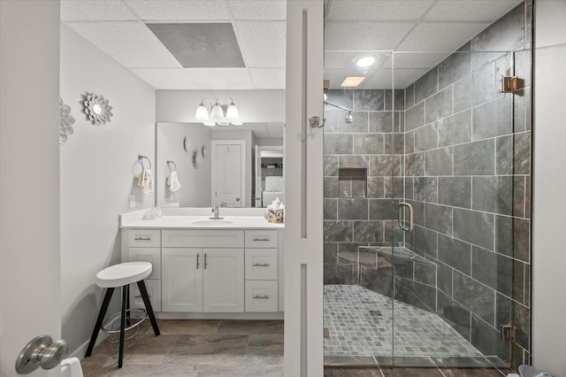 bathroom featuring a stall shower, vanity, and a drop ceiling