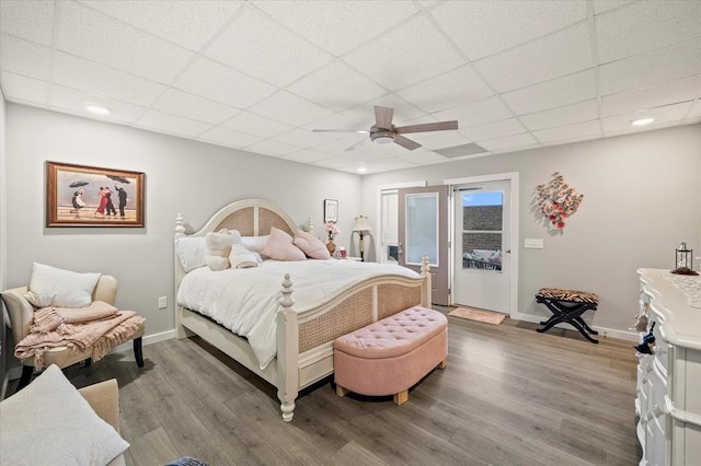 bedroom with a ceiling fan, baseboards, access to exterior, and wood finished floors
