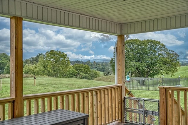 wooden deck featuring a lawn and fence