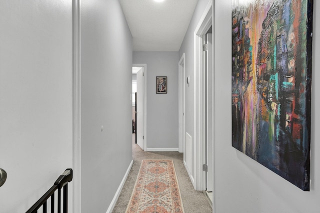 hallway with baseboards and carpet