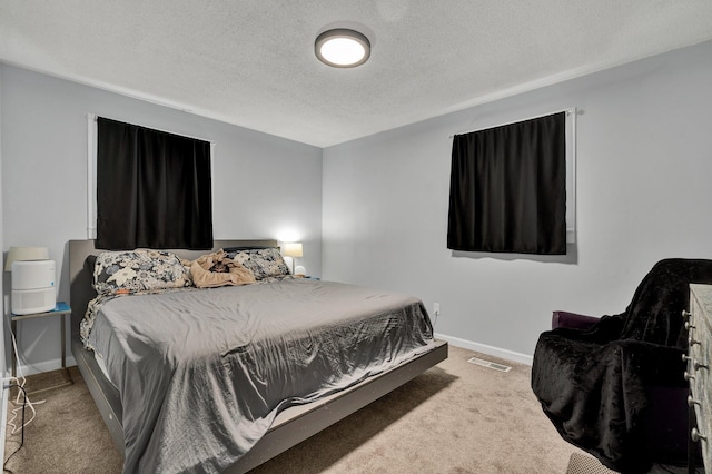 bedroom featuring carpet, baseboards, a textured ceiling, and visible vents
