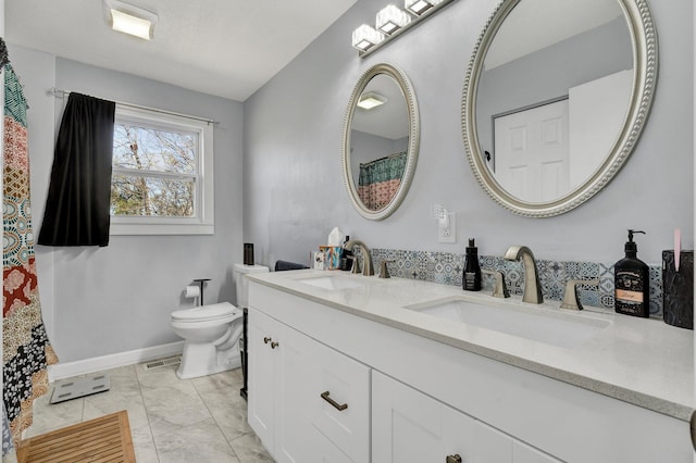 full bath with toilet, a sink, double vanity, and visible vents