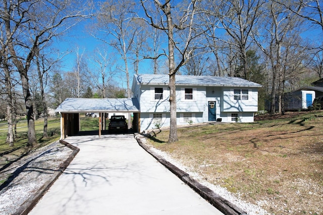 raised ranch featuring a front yard, an attached carport, and concrete driveway