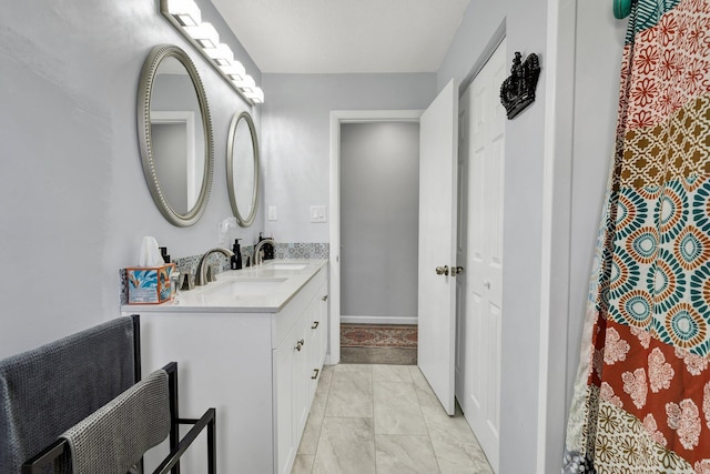 full bathroom with double vanity and a sink