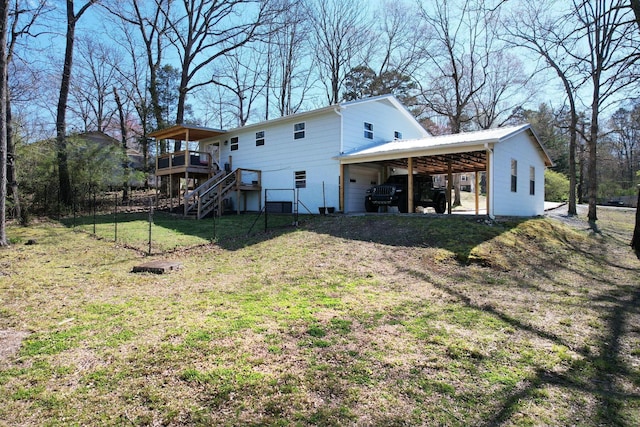 rear view of house featuring stairway, an attached carport, a deck, fence, and a lawn