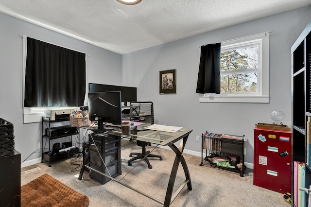 carpeted home office featuring baseboards and a textured ceiling