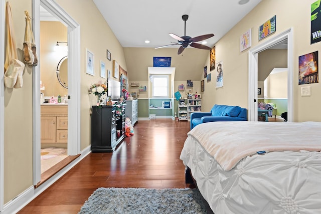 bedroom with ensuite bath, baseboards, and wood finished floors