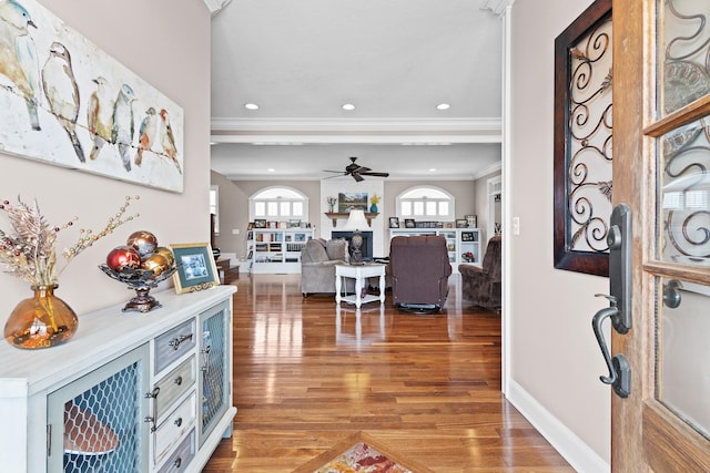 foyer entrance featuring crown molding, baseboards, ceiling fan, wood finished floors, and recessed lighting