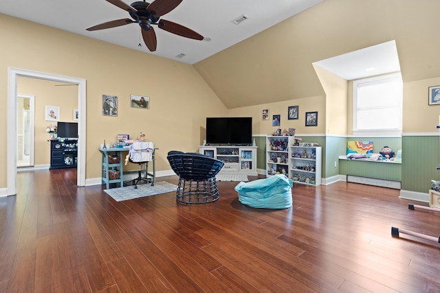 sitting room with a ceiling fan, wood finished floors, vaulted ceiling, and visible vents