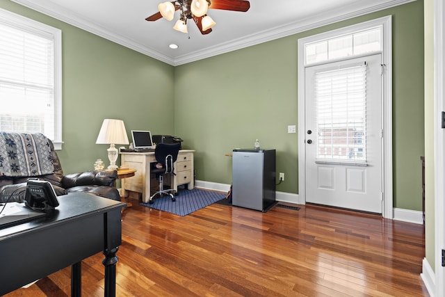 office area with hardwood / wood-style flooring, a ceiling fan, baseboards, visible vents, and ornamental molding