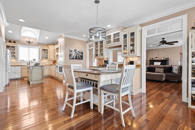 dining space with hardwood / wood-style floors, ornamental molding, ceiling fan with notable chandelier, and recessed lighting