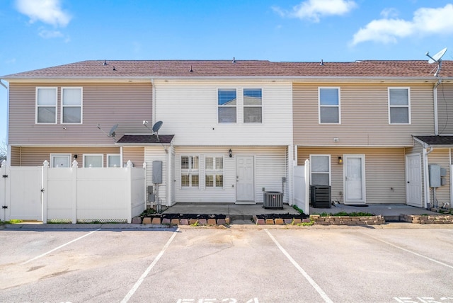 back of house featuring a gate, fence, uncovered parking, and a patio