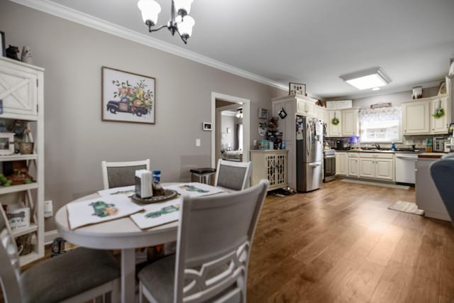 dining room featuring ornamental molding, a notable chandelier, and wood finished floors