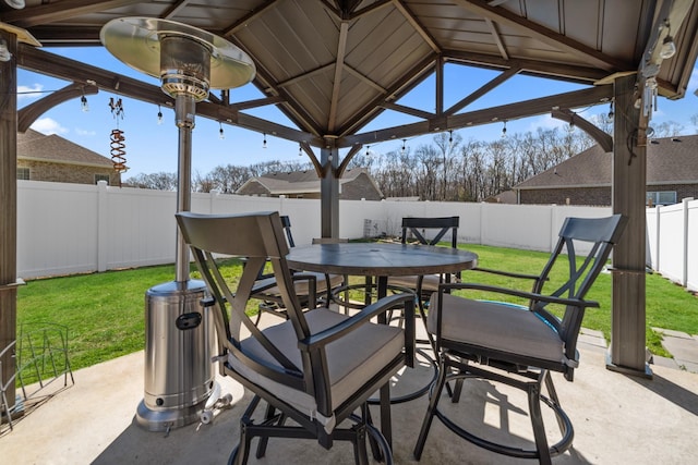 view of patio featuring a fenced backyard, outdoor dining area, and a gazebo